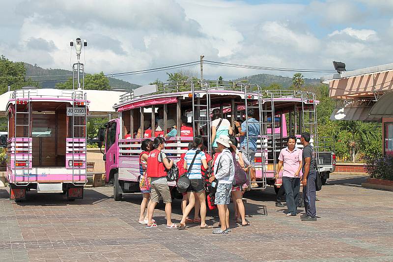 Touristen am Chalong Pier steigen in den Bus
